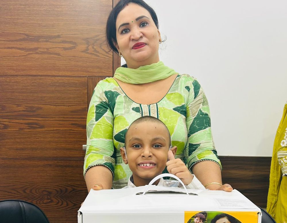 A mother and her son with his new cochlear implant kit