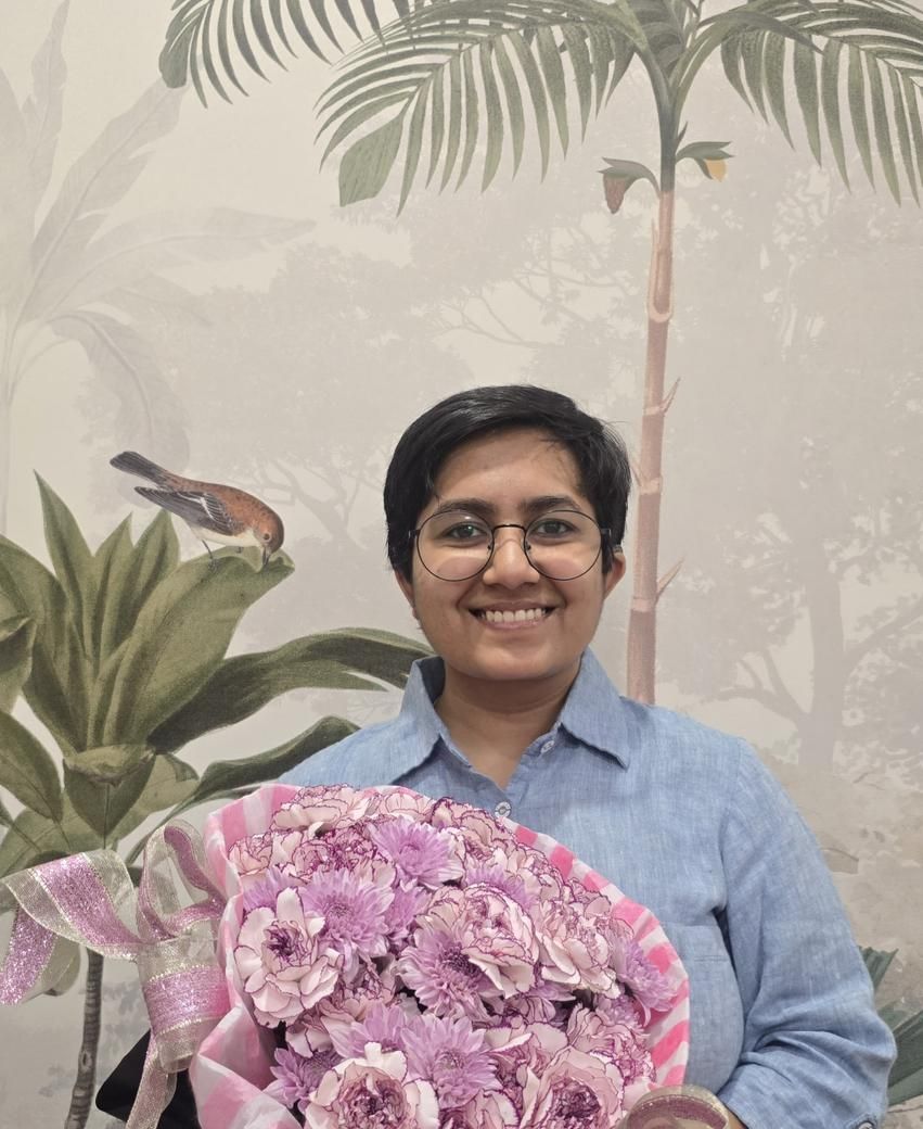 Tina, smiling with a bouquet of flowers
